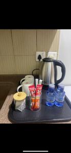 bandeja con tetera y otros artículos en una barra en غرفة بدورة مياة بدخول ذاتي, en Al Kharj