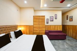 a hotel room with a bed and a bench at Hotel O The Indian Spices in Rao +29 photos