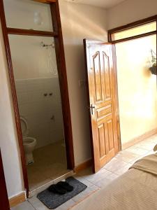 baño con aseo y puerta abierta en Loresho Luxe stay, en Nairobi