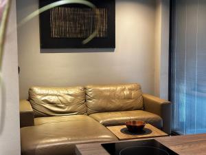 a living room with a leather couch and a table at Residence Pranterhof in Marlengo