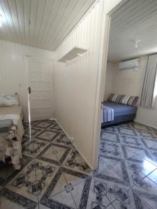 Pântano GrandeにあるChalé 138のタイルフロアの客室で、ベッド1台が備わります。 +3枚の写真