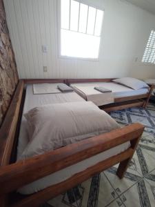 twee bedden in een kamer met een raam bij Chalé com garagem fechada in Pântano Grande +9 foto's