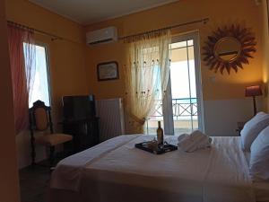 - une chambre avec un lit et une bouteille de vin dans l'établissement Theonimfi Villa for 5 with pool and Sea View, à Loutra Elenis