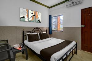 une chambre avec un lit, une table et une fenêtre dans l'établissement Hotel O Calangute Beach Road Formerly Crystal Holiday Homes, à Calangute