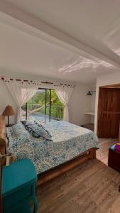 サレントにあるEl Regalo Finca Hostelの窓のある大きなベッドのある寝室