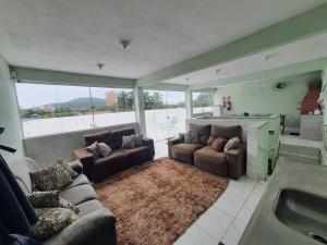 ein Wohnzimmer mit Sofas und eine Küche mit Badewanne in der Unterkunft Pousada Maranata in Guarujá