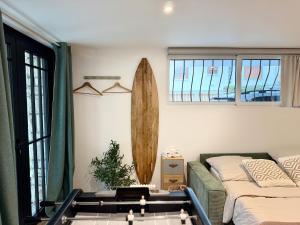 een woonkamer met een bed en een surfplank bij Superbe studio neuf & design - 20 min Versailles in Les Clayes-sous-Bois