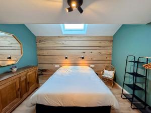 ein Schlafzimmer mit einem Bett mit einer Holzwand in der Unterkunft Le BrasÔvert in Bras