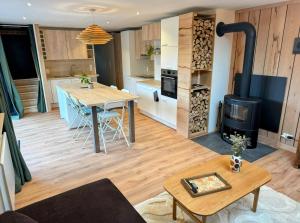 eine Küche und ein Wohnzimmer mit einem Holzofen in der Unterkunft Le BrasÔvert in Bras