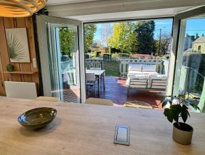 ein Zimmer mit einem Tisch und einer Glastür zu einer Terrasse in der Unterkunft Le BrasÔvert in Bras