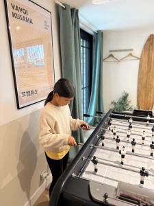 Una niña jugando al ajedrez en una mesa en Superbe studio neuf & design - 20 min Versailles, en Les Clayes-sous-Bois