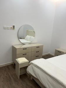ein Schlafzimmer mit einem Spiegel auf einer Kommode und einem Bett in der Unterkunft شقة فاخرة غرفة ماستر مع صالة in Ar Rass