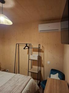 ein Schlafzimmer mit einem Bett, einem Stuhl und einem Tisch in der Unterkunft Localodge - chalet en bois in Caves