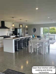 eine offene Küche mit Tisch und Stühlen in der Unterkunft Peaceful retreat in big sky country, near beach in Mangawhai