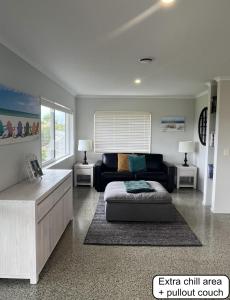 ein Wohnzimmer mit Sofa und Tisch in der Unterkunft Peaceful retreat in big sky country, near beach in Mangawhai + 13 Fotos