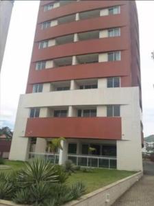 a tall red and white building with plants in front of it at Flat no Centro de Campo Grande in Campo Grande +3 photos