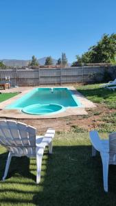 een zwembad met twee witte stoelen bij Cabañas Venecia in El Monte