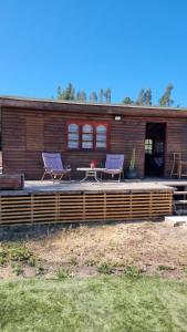 twee stoelen en een tafel voor een huis bij Cabañas Venecia in El Monte