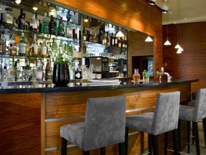 a bar with two chairs and a counter with bottles at K+K Hotel Fenix in Prague