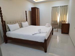 a bedroom with a bed with white sheets and a window at Farm Stay Genome in Jāmb