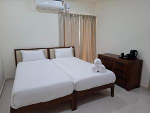 a bedroom with a bed and a dresser with a white bedspread at Farm Stay Genome in Jāmb