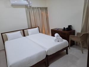 a bedroom with two beds and a desk and a chair at Farm Stay Genome in Jāmb +7 photos