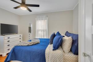 a bedroom with a blue bed and a tv at The Game House Arcade West Hartford in West Hartford