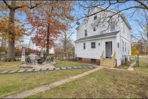 a white house with a table and chairs in a yard at The Game House Arcade West Hartford in West Hartford