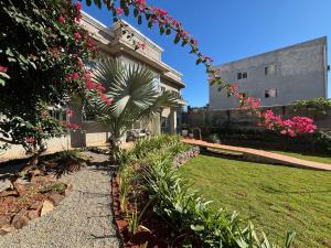 伊瓜苏Ravello Residencial - Próximo ao Paraguai e Centro de Foz do Iguaçu的一座种有粉红色花卉的花园及一座建筑