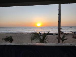 a sunset on the beach with a view of the ocean at Maison Kerniko in Warang