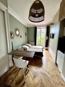 ein Schlafzimmer mit zwei Betten und einem Tisch und Stühlen in der Unterkunft Bois Émeraude in La Celle-sous-Gouzon