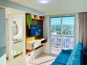 ein Wohnzimmer mit einer blauen Couch und einem großen Fenster in der Unterkunft MyPlace Benfica By Holiday Stays in Fortaleza
