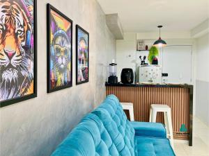 ein Wohnzimmer mit einem blauen Sofa und Gemälden an der Wand in der Unterkunft MyPlace Benfica By Holiday Stays in Fortaleza