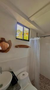 サレントにあるEl Regalo Finca Hostelのトイレ、洗面台、窓のあるバスルーム