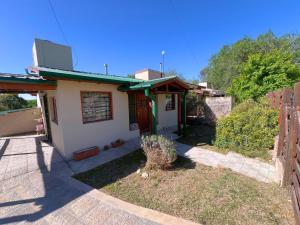 a small house with a fence in the yard at La Maru in Villa Giardino