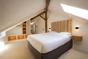 ein Schlafzimmer mit einem großen weißen Bett mit einem hölzernen Kopfteil in der Unterkunft New ! Sublime loft, Spa & Sauna, Place des Vosges in Épinal + 25 Fotos