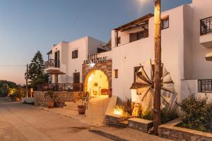 ein weißes Haus mit einem Torbogen davor in der Unterkunft Anemomilos Beach hotel in Agia Anna