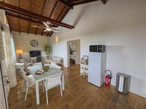 a kitchen and living room with a table and a refrigerator at Blue Horizon in Vieux-Habitants