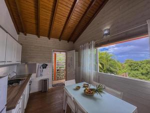 a kitchen with a table and a large window at Blue Horizon in Vieux-Habitants