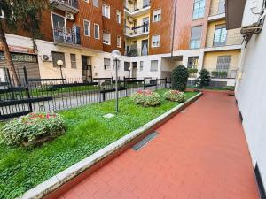 a walkway in a courtyard with buildings and flowers at NEW Brenta 10 minutes To Duomo M3-15 minutes to Linate - Full furnished APT with AC, Wi-fi and more in Milan