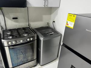 a kitchen with a stove and a refrigerator at Estudio 1 Cerca PLAYA Y CENTRO HISTORICO in Santa Marta