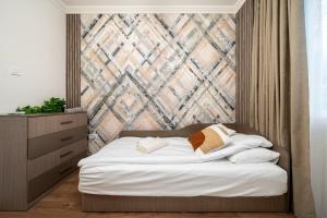 ein Schlafzimmer mit einem Bett mit einer Wand in der Unterkunft Бизнес & Арт апартамент - до Панаира и Капана in Plowdiw