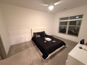 a bedroom with a black bed in a white room at Modern Midtown Retreat Luxury Car Option in Kansas City