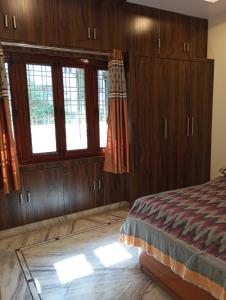 a bedroom with wooden walls and a bed with windows at EnDai House - Kalyanpuri, Uppal in Hyderabad