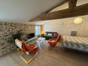 ein Wohnzimmer mit Sofa und Bett in der Unterkunft Gîte du Cerisier - Studio nature détente in Vallet + 5 Fotos