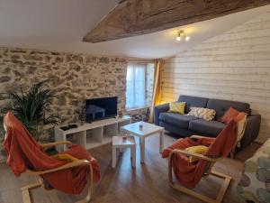 ein Wohnzimmer mit Sofa und Tisch in der Unterkunft Gîte du Cerisier - Studio nature détente in Vallet