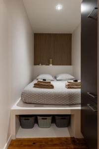 a bedroom with a bed with baskets under it at L'Odile - 2 pers hypercenter in Bourg-en-Bresse