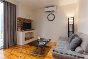 a living room with a couch and a table at L'Odile - 2 pers hypercenter in Bourg-en-Bresse