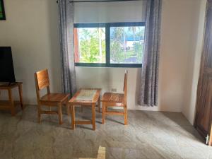 a dining room with a table and two chairs and a window at The Ridge-Coconut Cottage in Buff Bay