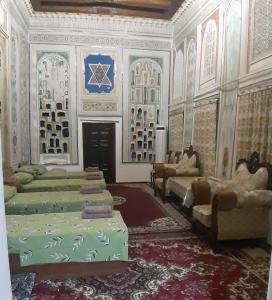 a room with four beds and chairs in it at Mekhtarin in Bukhara +6 photos